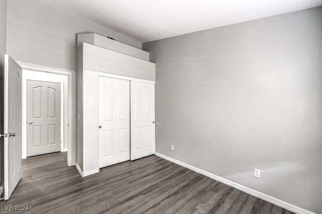 unfurnished bedroom featuring dark hardwood / wood-style flooring and a closet