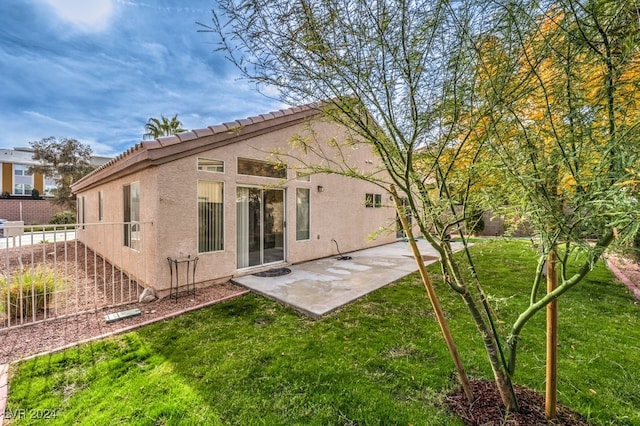 back of property featuring a lawn and a patio area