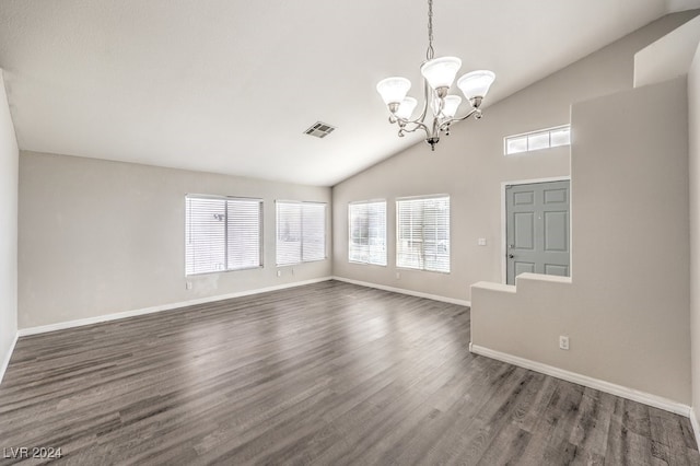 spare room with lofted ceiling, dark wood-type flooring, and a chandelier