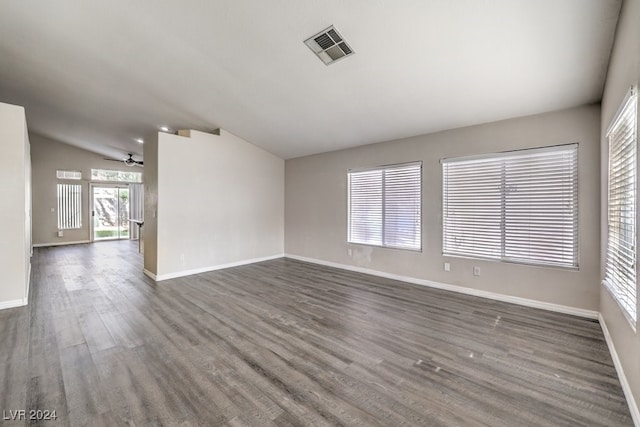 unfurnished room featuring dark hardwood / wood-style floors, vaulted ceiling, and ceiling fan