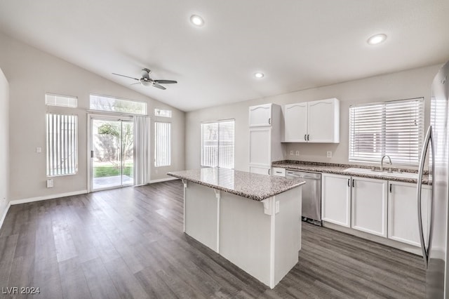 kitchen with dishwasher, a center island, white cabinets, ceiling fan, and light stone countertops