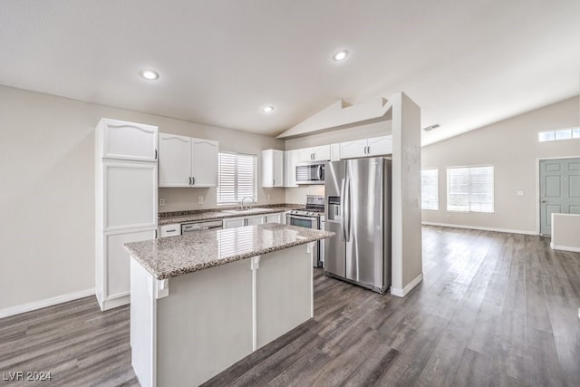 kitchen with a center island, white cabinets, vaulted ceiling, and appliances with stainless steel finishes