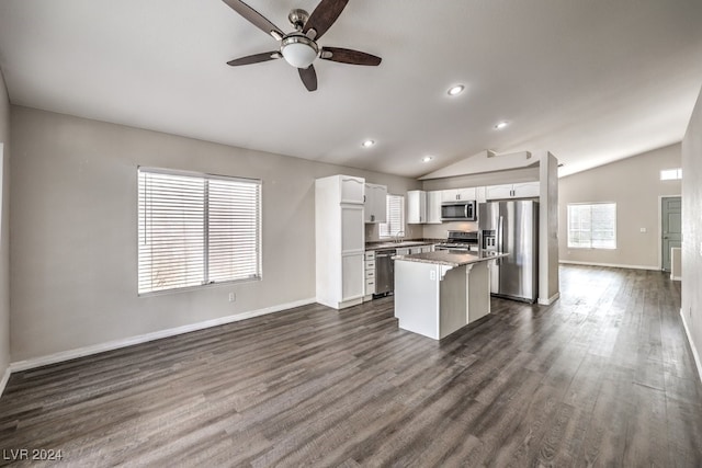 kitchen featuring appliances with stainless steel finishes, dark hardwood / wood-style flooring, white cabinets, a kitchen island, and lofted ceiling