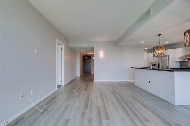 unfurnished living room featuring light hardwood / wood-style flooring and a notable chandelier