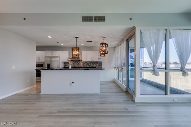 kitchen with appliances with stainless steel finishes, white cabinetry, and a wealth of natural light