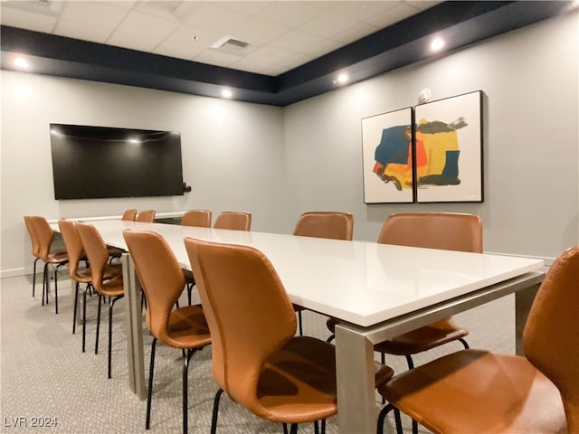 dining area with a drop ceiling and light carpet