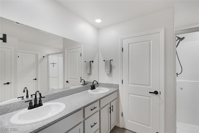 bathroom with a shower with door and vanity