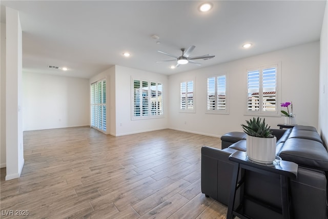 living room featuring ceiling fan, a wealth of natural light, and light hardwood / wood-style flooring