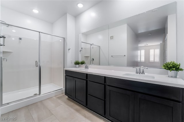 bathroom with a shower with shower door, vanity, and tile patterned floors