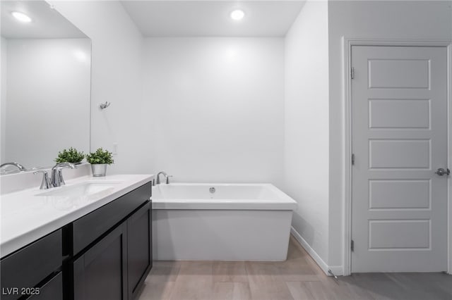 bathroom with a tub to relax in and vanity