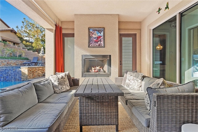 view of patio with a swimming pool and an outdoor living space with a fireplace