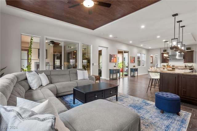 living room with wood ceiling, dark hardwood / wood-style floors, and a healthy amount of sunlight