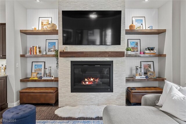 living room with a stone fireplace and hardwood / wood-style floors