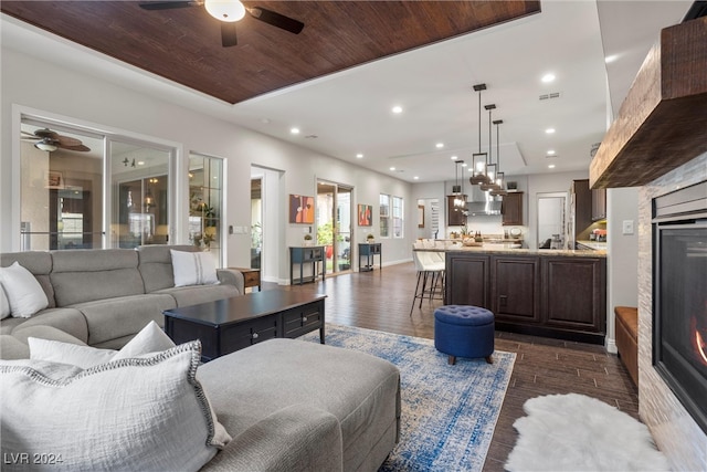 living room featuring wood ceiling, ceiling fan, and dark hardwood / wood-style flooring