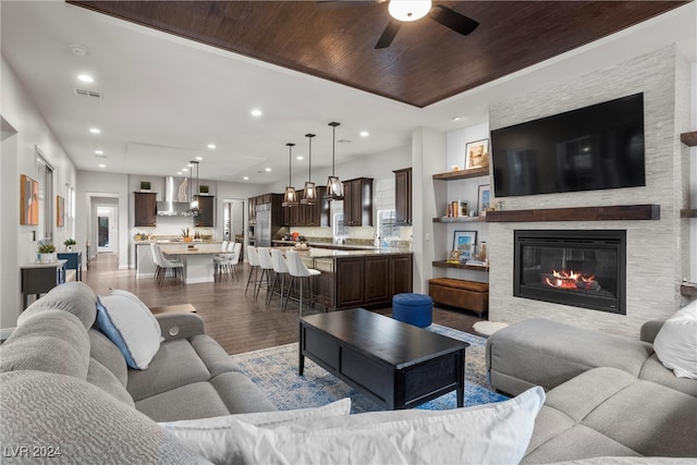 living room with light hardwood / wood-style floors, wood ceiling, and ceiling fan