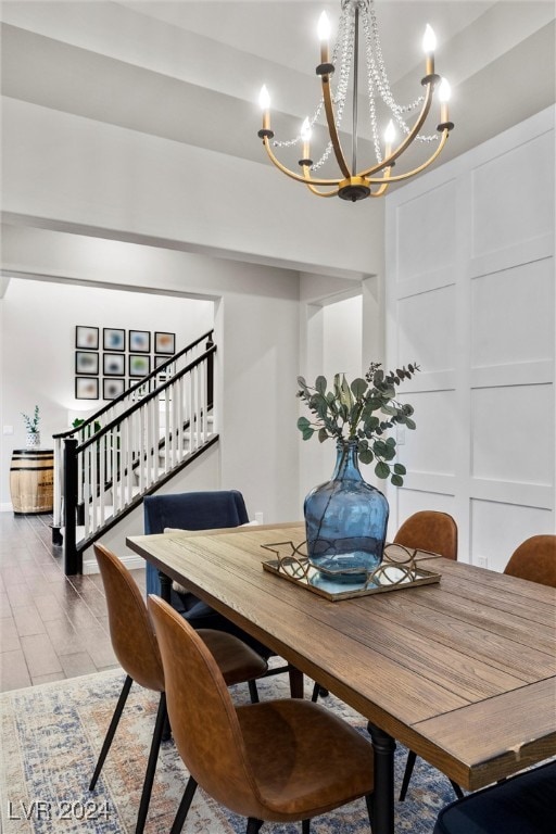 dining space with wood-type flooring and an inviting chandelier