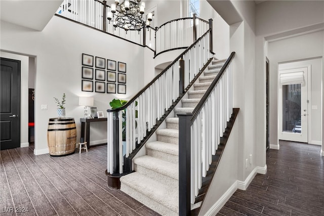 stairs with a towering ceiling and wood-type flooring