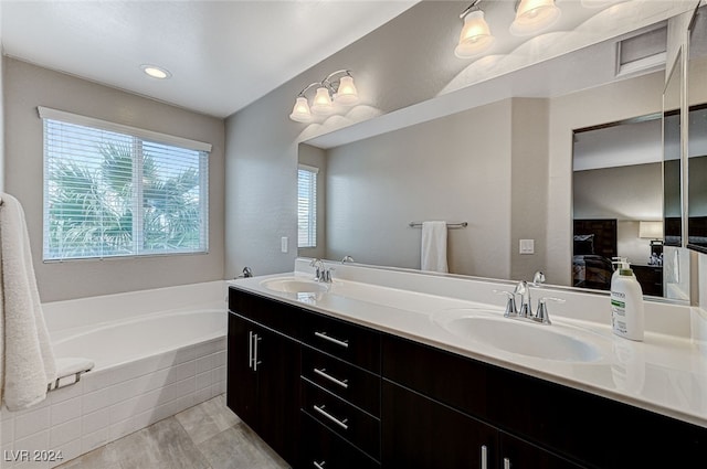 bathroom with vanity and tiled tub