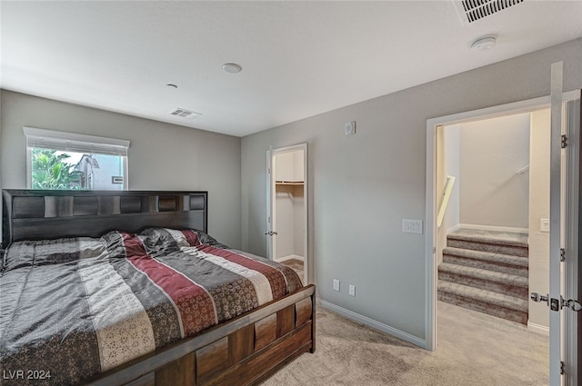 carpeted bedroom with a spacious closet and a closet