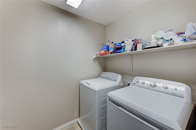 washroom with a textured ceiling and washer and clothes dryer