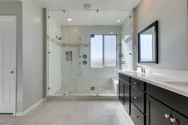 bathroom featuring a shower with shower door and vanity