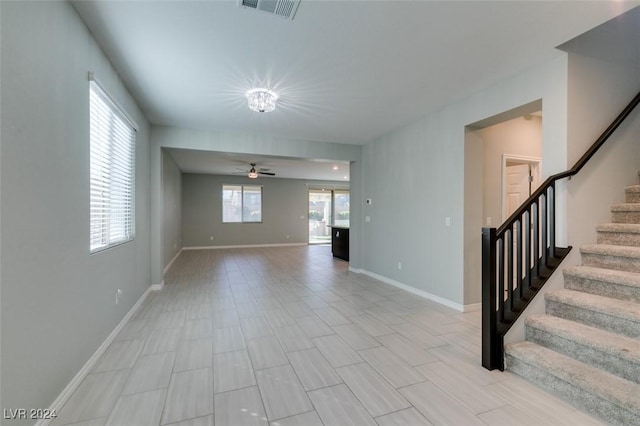 unfurnished living room featuring ceiling fan and a healthy amount of sunlight