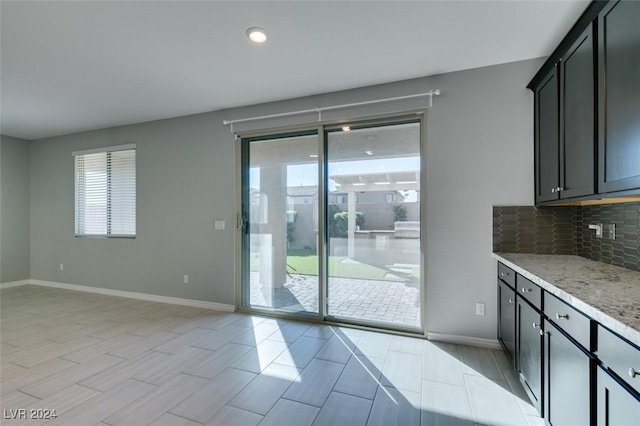 interior space featuring decorative backsplash and light stone countertops