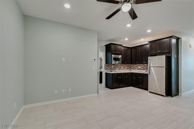 kitchen featuring ceiling fan, backsplash, dark brown cabinetry, appliances with stainless steel finishes, and light tile patterned floors