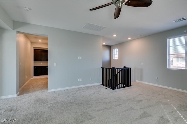 spare room featuring ceiling fan and light colored carpet