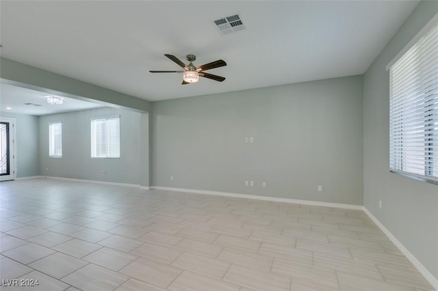 tiled spare room with ceiling fan