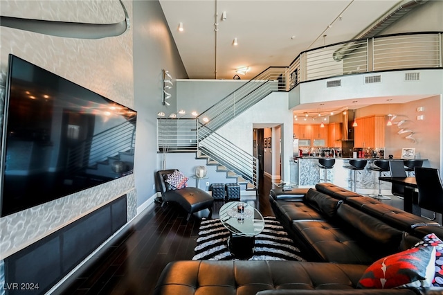 living room with a towering ceiling and hardwood / wood-style floors