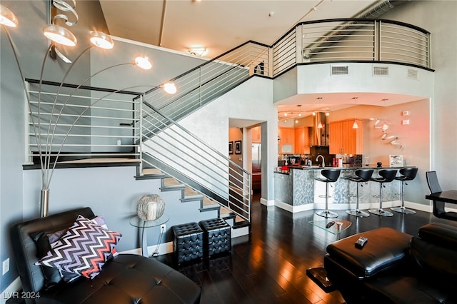 living room featuring sink, a high ceiling, and wood-type flooring