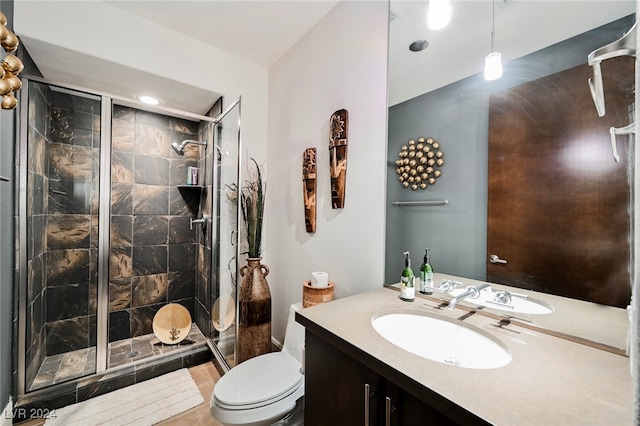 bathroom with vanity, toilet, tile patterned floors, and a shower with door