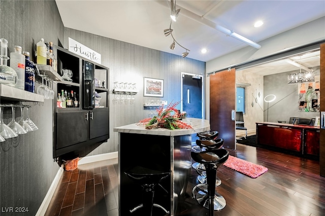 kitchen featuring dark wood-type flooring, a barn door, and a kitchen breakfast bar