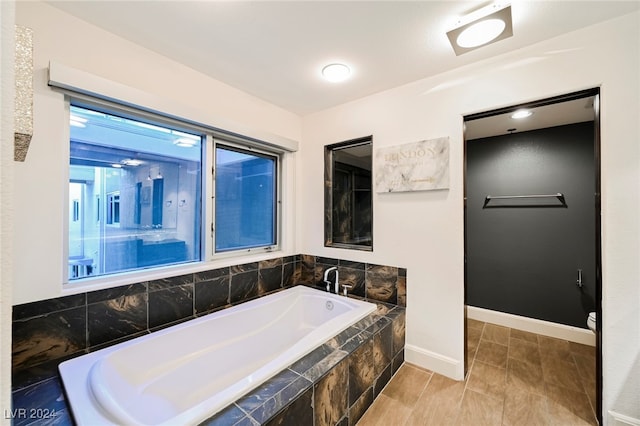 bathroom featuring toilet and tiled tub