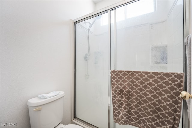 bathroom featuring toilet and an enclosed shower