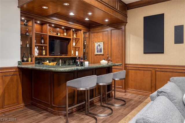 bar featuring light hardwood / wood-style floors, crown molding, tasteful backsplash, and built in features