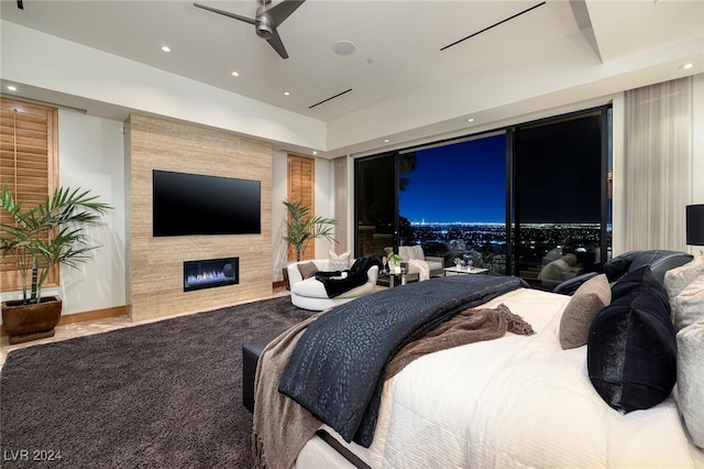 bedroom featuring carpet floors, access to exterior, a large fireplace, and ceiling fan