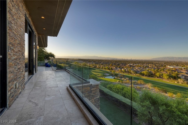 balcony at dusk featuring a mountain view