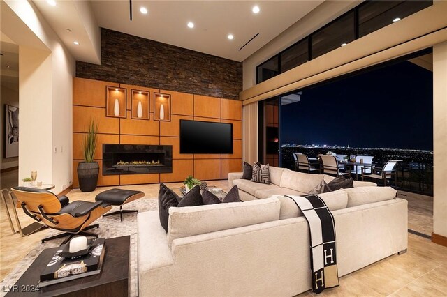 tiled living room featuring a fireplace and a towering ceiling