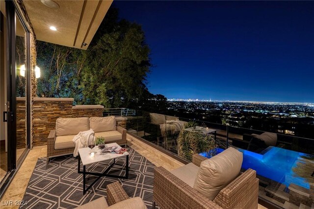 patio at twilight with an outdoor living space and a balcony