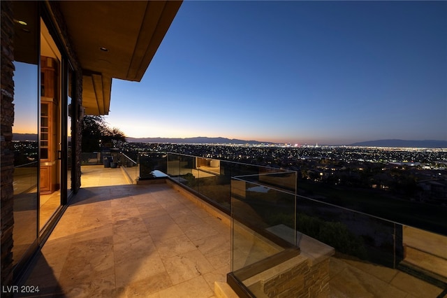 balcony at dusk featuring a mountain view