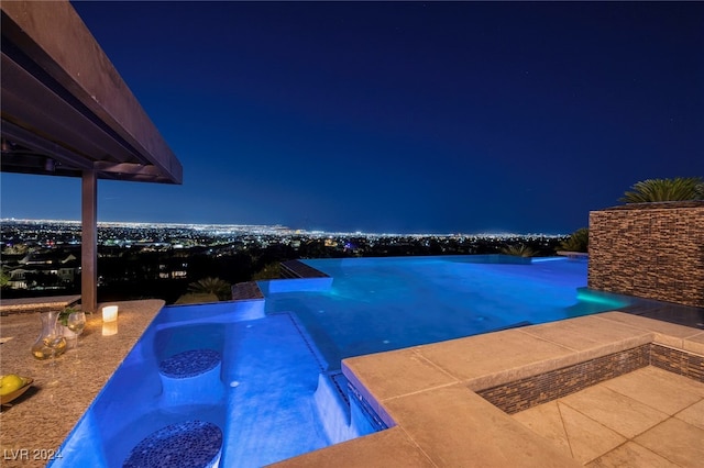 pool at twilight featuring a patio