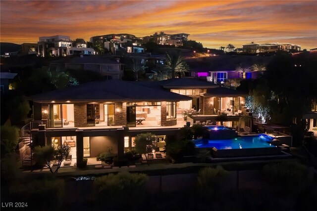 back house at dusk with a patio area