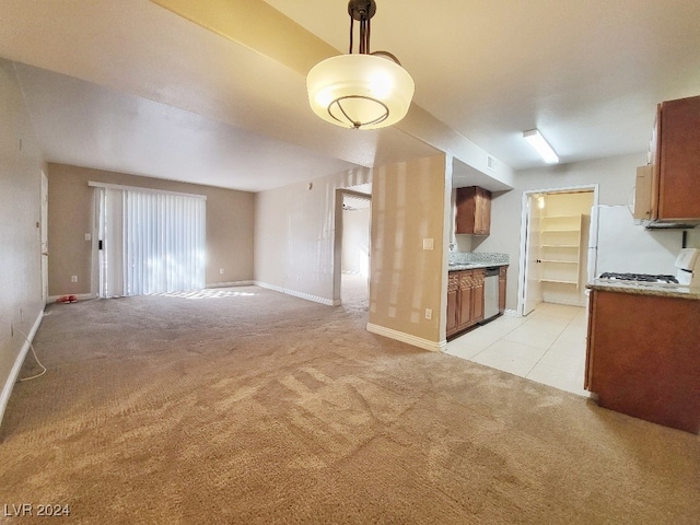 kitchen with light carpet, decorative light fixtures, stainless steel dishwasher, and white range