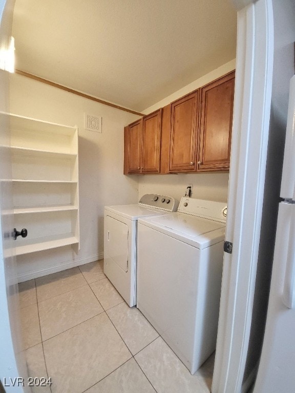 washroom with cabinets, light tile patterned flooring, and separate washer and dryer