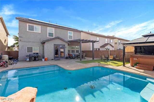 view of swimming pool featuring a jacuzzi, area for grilling, a patio, and a pergola