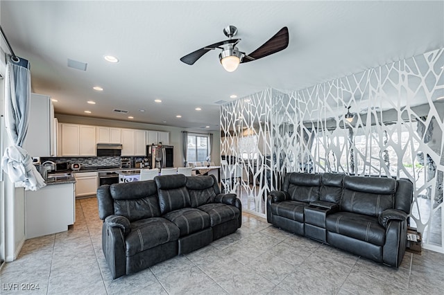 tiled living room featuring ceiling fan and sink