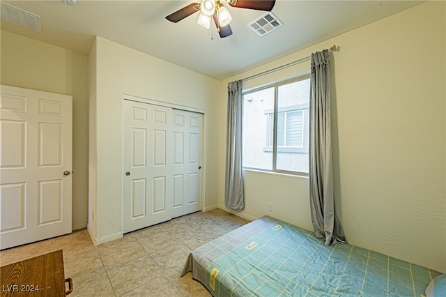 bedroom featuring a closet, light tile patterned flooring, and ceiling fan