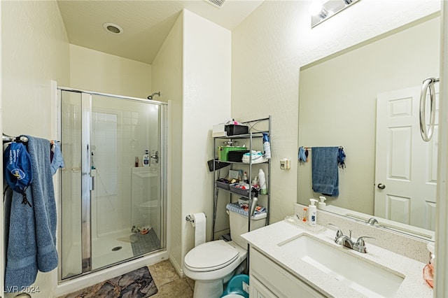 bathroom with vanity, toilet, tile patterned floors, and a shower with shower door